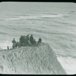 A crowd standing on a clifftop during the salvage operation from the Eider. The plate has a J. Dore sticker on it and is captioned 'The wreck of the Eider - watching the wreck from the cliff'. The Eider was carrying maize, cotton, gold, silver and mail when she ran aground on Atherfield Ledge on 31st January 1892. Salvage continued until 29th March when she was towed to Southampton