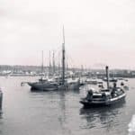 Harbour scene at an unidentified location although probably Cowes. Partial remains of a sticker reading '...and lighthouse', but this does not appear to relate to the image