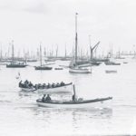 Boats on the water at Cowes. A small steam launch and rowing boat are in the foreground