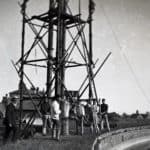 Group of men standing round a scaffolding tower