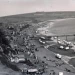 View of Sandown's beaches and seafront from the cliffs. A large group of people are watching performers on the Esplanade