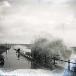 Man on the seafront at Sandown dodging the huge waves which are crashing against the sea wall