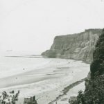 View of Dunnose Point and Luccombe. A small number of bathing huts can be seen on the beach