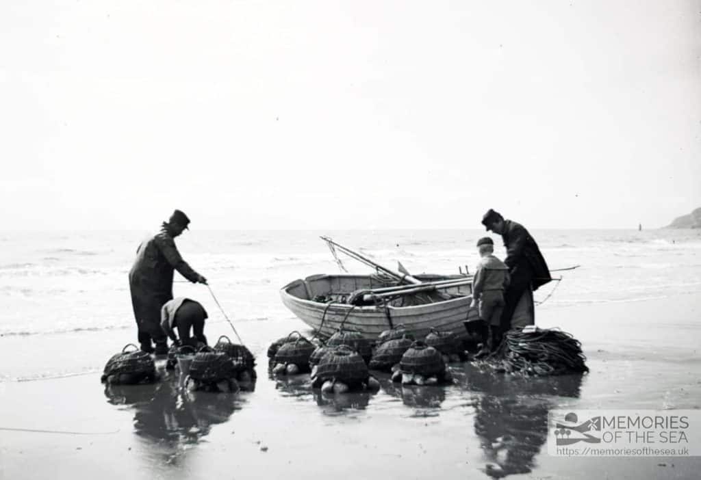 Open boat returning to shore at Ventnor, fishermen unload lobster pots