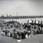 Two people entertaining crowds underneath Sandown pier