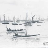 Boats on the water at Cowes. A small steam launch and rowing boat are in the foreground